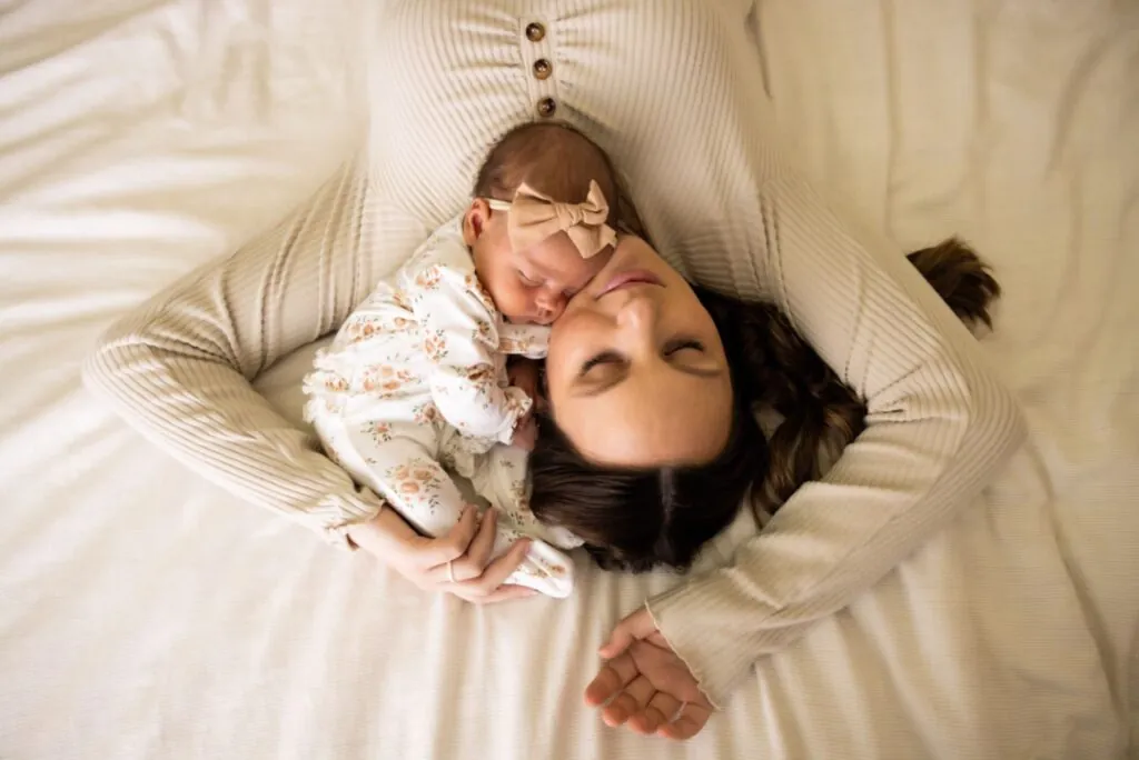 A first-time mom and her sleeping newborn during a newborn photography session